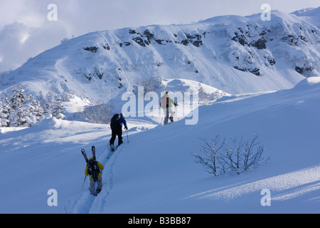 Backcountry sciatori collina ascendente, furano, Hokkaido, Giappone Foto Stock