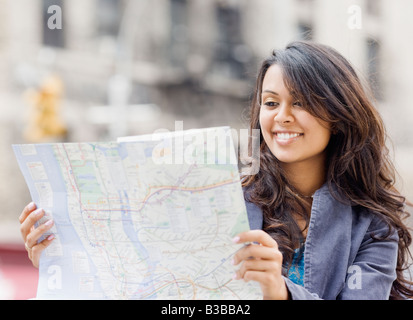 Razza mista donna che guarda la mappa Foto Stock