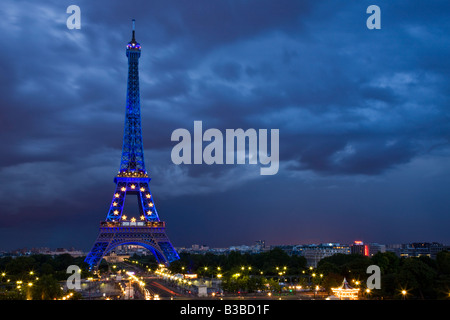 Ampio angolo di visione notturna della Torre Eiffel illuminata con speciali star & luci blu, Paris cityscape, estate al crepuscolo con avvicinamento tempesta. Solo uso editoriale. Foto Stock
