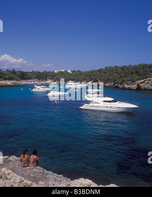 Scena in Cala Mondrago Parco naturale - con barche a motore e barche a ancoraggio - vicino a Cala D'Or, costa orientale di Mallorca. Foto Stock