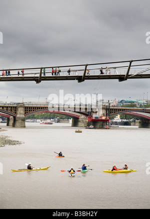 Lezioni di kayak sul fiume Tamigi sotto la passerella del millennio in London Blackfriars Rail Bridge in background Foto Stock