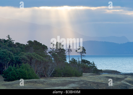 Sunray glisten sull'oceano appena dopo il tramonto dietro Helliwell Park in Hornby Isola, British Columbia, Canada. Foto Stock