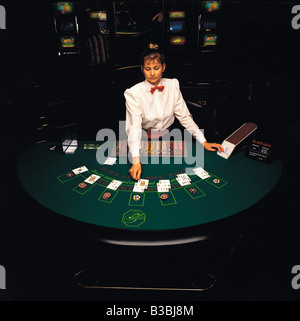 Vista aerea del croupier femmina mostra carte in casinò al tavolo del blackjack. Foto Stock