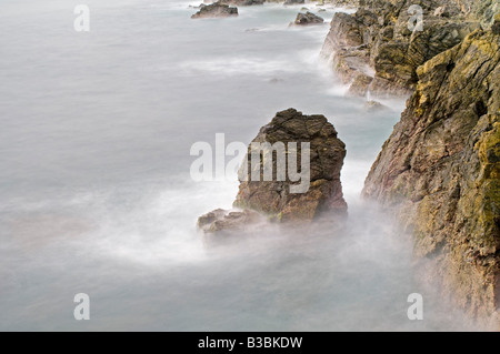 ZIHUATANEJO, Messico - una lunga esposizione delle onde che si infrangono contro gli scogli sulla capezzagna a Zihuatanejo, Messico Foto Stock