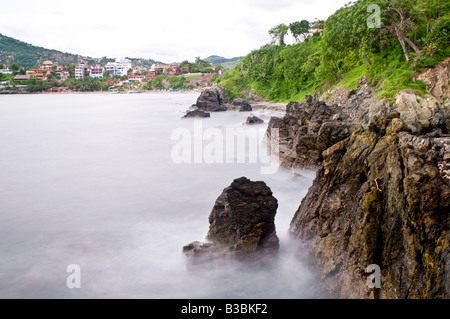 ZIHUATANEJO, Messico - una lunga esposizione delle onde che si infrangono contro gli scogli sulla capezzagna a Zihuatanejo, Messico Foto Stock