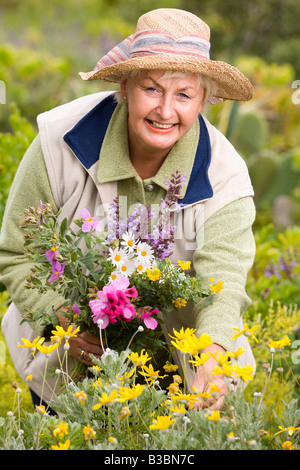 Ritratto di donna in prato, fiori di raccolta Foto Stock