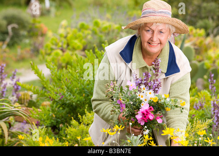 Ritratto di donna in prato, fiori di raccolta Foto Stock