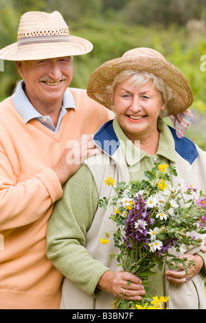 Ritratto di giovane donna fiori di contenimento Foto Stock