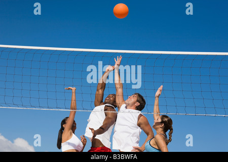 Multi-etnico amici giocando a pallavolo Foto Stock