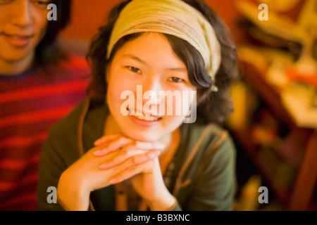 Donna asiatica in appoggio il mento sulle mani Foto Stock