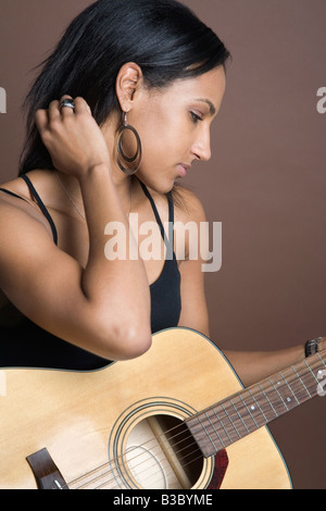 Razza mista donna tenendo la chitarra Foto Stock