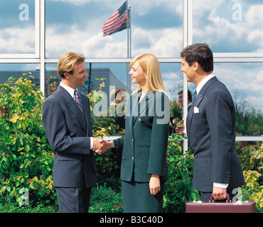 Vista laterale della gente di affari di handshaking ufficio esterno Foto Stock