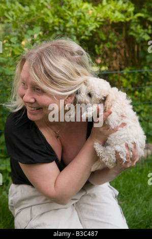 Una donna con il suo cucciolo barboncino Foto Stock