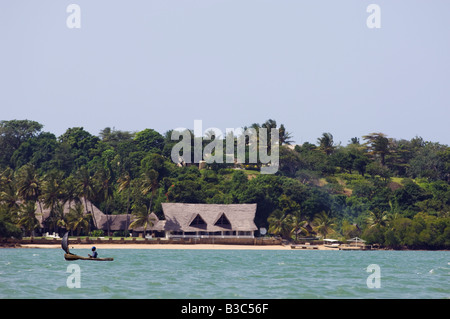 Kenya, Kilifi. Un pescatore locale vele la sua piroga nella parte anteriore di un lodge sulle rive di Kilifi Creek. Foto Stock