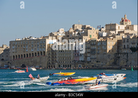 Malta, La Valletta. I concorrenti nel mondo Powerboat Championships drive in di La Valletta Grand Harbour passando davanti a Senglea elegante waterfront palazzi. Foto Stock