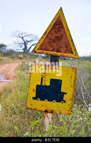 Kenya, Tsavo. Vecchia ferrovia segno di incrocio vicino all'approccio al Tsavo stazione ferroviaria. Tsavo è stato il luogo in cui due man-eating lions divorato ventotto coolies Indiani e molti lavoratori africani nel 1898, mantenendo la costruzione di un ponte sulla ferrovia Uganda per diversi mesi. Foto Stock