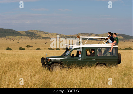 Kenia Masai Mara riserva nazionale. Famiglia su un game drive in una Toyota Landcruiser in aperta pianure erbose del Masai Mara. Foto Stock