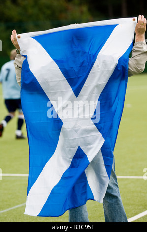 Scottish Football fan drappeggiati in si intraversa bandiera. Foto Stock