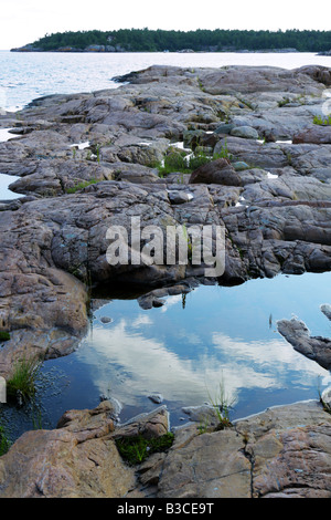 Red spiaggia rocciosa e di riflessioni di cielo blu in Georgian Bay Ontario Foto Stock