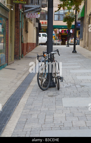 Le biciclette in appoggio contro una lampada posta in una San Francisco alley downtown Foto Stock