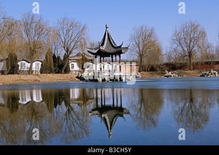 Cina, Pechino. Tempio Beiputuo e film studio Imposta posizione, un padiglione riflettendo in un lago. Foto Stock