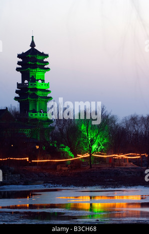 Cina, Pechino. Tempio Beiputuo e film studio Imposta posizione, una pagoda illuminata di notte. Foto Stock