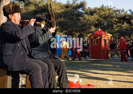 Cina, Pechino. Anno Nuovo Cinese Festa della Primavera - Parco Ditan fiera del tempio un gruppo di musicisti di suonare per un Palaquin processione. Foto Stock