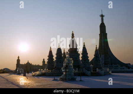 La Cina, a nord-est della Cina, Provincia di Heilongjiang, Harbin città. Lanterna di ghiaccio Festival. Tramonto su una scultura di ghiaccio replica di Bangkok il Wat Po. Foto Stock