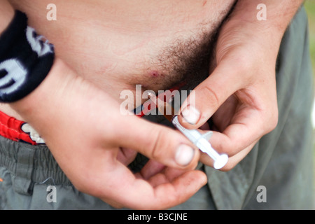 Un giovane uomo che utilizza una miscela di cocaina ed eroina in Berlino. Foto Stock