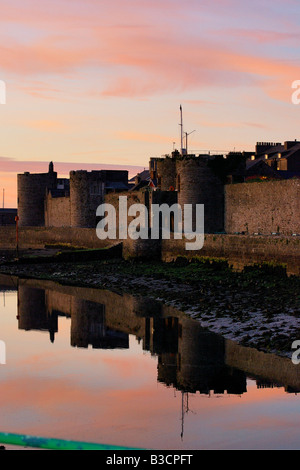 Le pareti esterne del Caernarfon Castle sulla costa del Galles del Nord in tarda serata sole Foto Stock