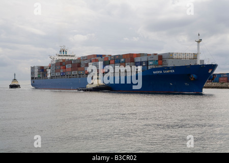 Contenitore nave Maersk Dampier, è guidata nel porto di Fremantle, Western Australia, da due barche rimorchiatore Foto Stock