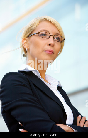 Giovane imprenditrice contemplando al di fuori di edificio per uffici Foto Stock