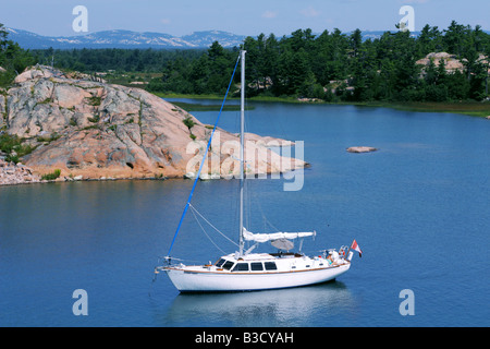 Barca a vela ormeggiata su le acque turchesi di trenta mila isole in Georgian Bay Ontario Foto Stock