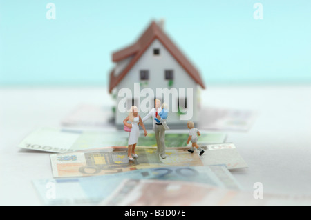 Pastic figurine sulle banconote, casa in background Foto Stock