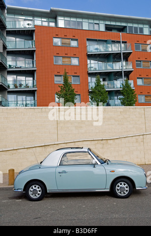 Un Nissan Figaro retrò auto al di fuori appartamenti di recente costruzione a Neptune Quay, Ipswich, Suffolk, Regno Unito. Foto Stock