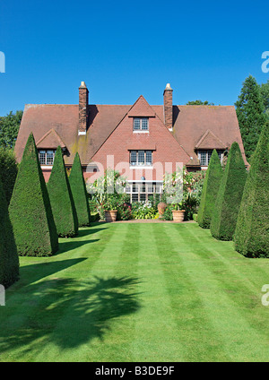 Casa e giardino erboso con topiaria da a vicarage giardino est ruston norfolk England Regno Unito Foto Stock