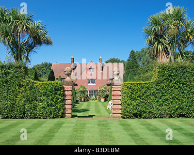 Casa e giardino erboso con topiaria da a vicarage giardino est ruston norfolk England Regno Unito Foto Stock