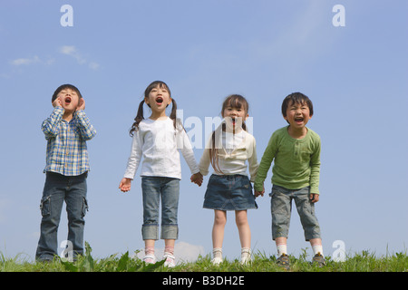 I bambini in piedi in una fila e urlare insieme Foto Stock