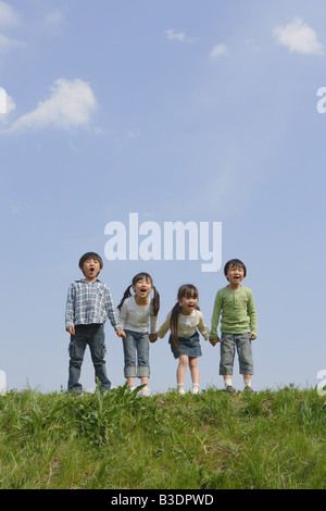 I bambini in piedi in una fila e urlare insieme Foto Stock