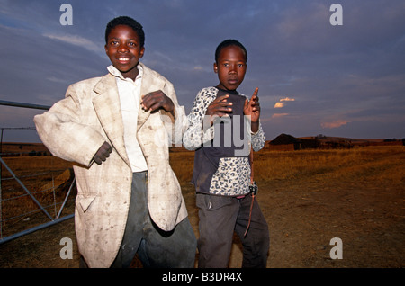 Ragazzi che pongono nel campo gateway, uno in tuta sovradimensionato camicia, ritratto, Sud Africa e Africa Foto Stock