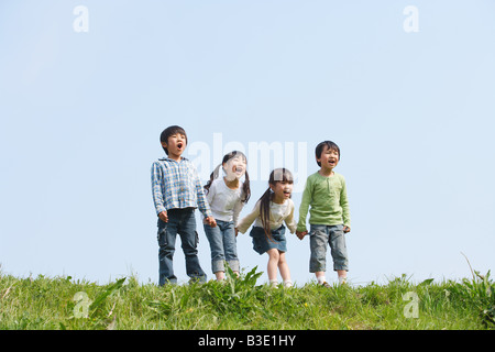 I bambini in piedi in una fila e urlare insieme Foto Stock