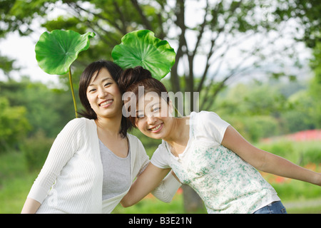 Giovani donne sorridenti in posa per le riprese della telecamera Foto Stock