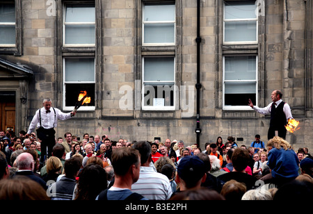 Giocolieri con torce fiammeggianti intrattenere la folla in Edinburgh Royal Mile durante il Festival Foto Stock