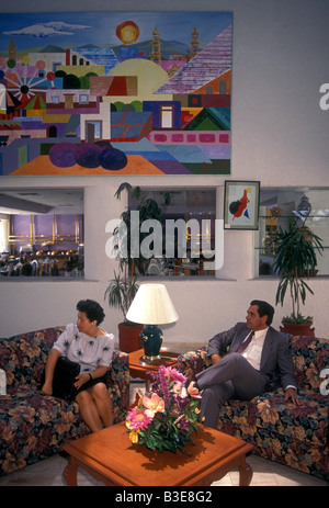 2 messicano due persone, uomo e donna, hotel gli ospiti seduti nella hall dell'hotel nella città di Aguascalientes in Aguascalientes stato in Messico Foto Stock
