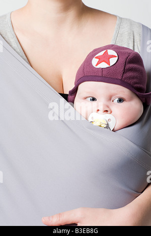 Un bambino in una fionda bambino Foto Stock