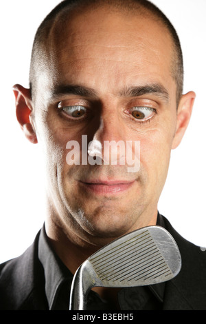 Croce maschio eyed tenendo un golf club Foto Stock