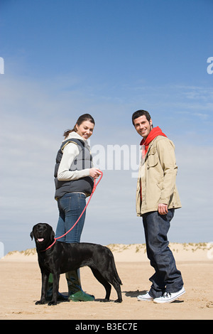 Coppia con cane sulla spiaggia Foto Stock