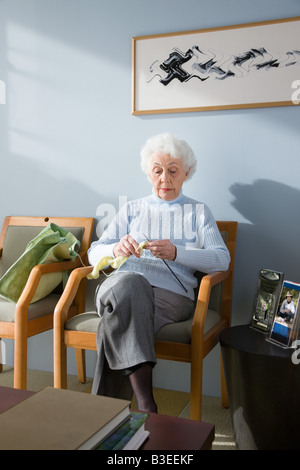 Un senior donna in attesa in un ufficio medici Foto Stock