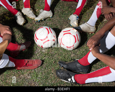 Palloni da calcio e le gambe dei calciatori Foto Stock