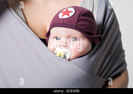 Un bambino in una fionda bambino Foto Stock